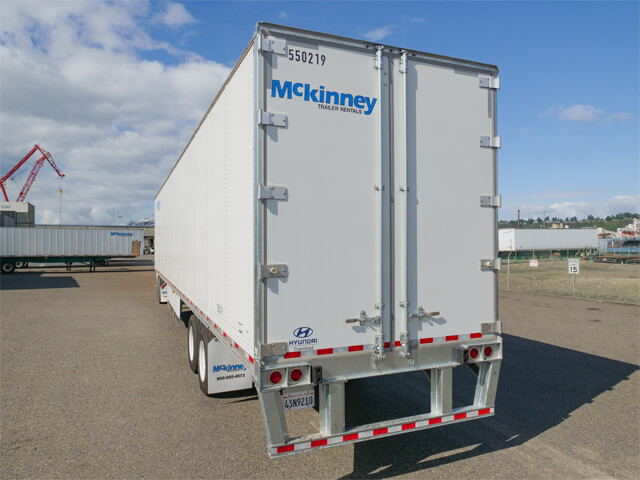 Rear view of a Mckinney semi-trailer parked in a lot